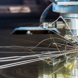 A photograph of a laser, metal-cuttting, CNC, automated, CNC machine tool in operation cutting sheet steel.